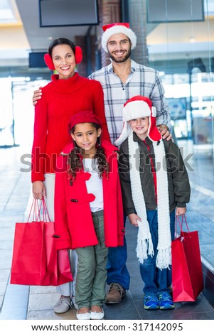 Happy family looking at camera in shopping mall