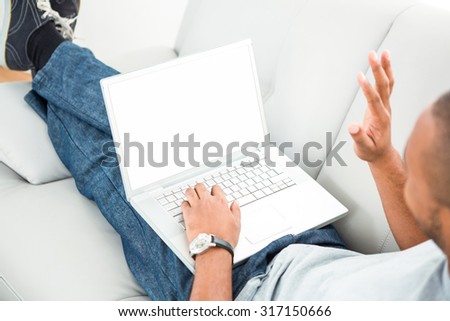 Happy man waving hand during video chatting on laptop at home