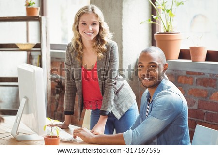 Smiling man and woman working in creative office