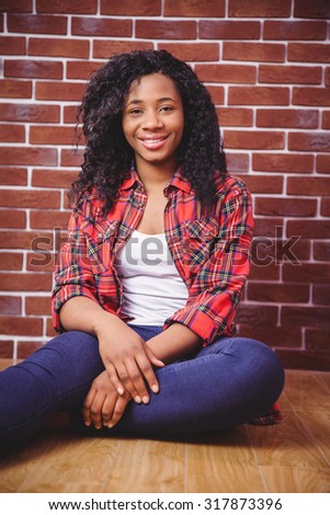 Hipster smiling at the camera on red brick background