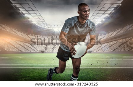 Confident athlete running with rugby ball against rugby arena