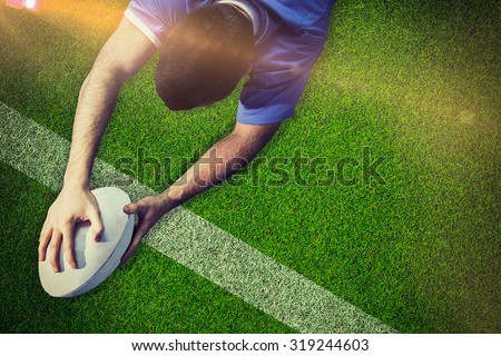 A rugby player scoring a try against pitch with line