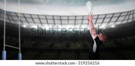 Rugby player catching a rugby ball against rugby pitch