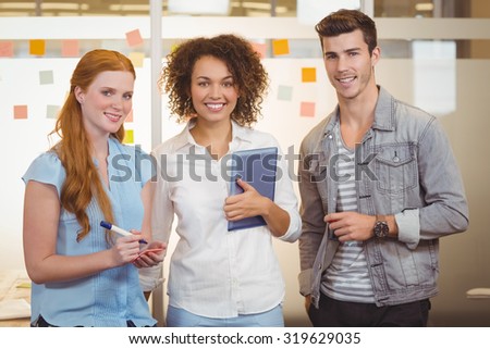 Portrait of confident business people standing in office during meeting