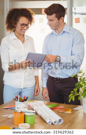 Business people holding document while standing by table in office