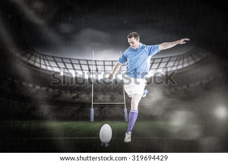 Rugby player doing a drop kick against rugby stadium