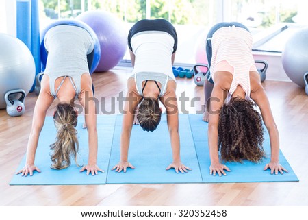 Women doing downward dog position in fitness studio