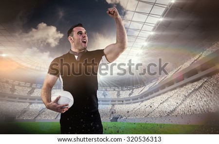 Rugby player cheering with the ball against rugby stadium