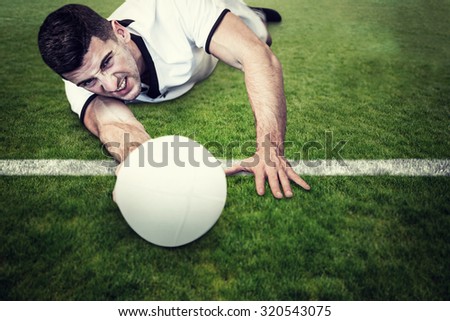 Man lying down while holding ball against green field