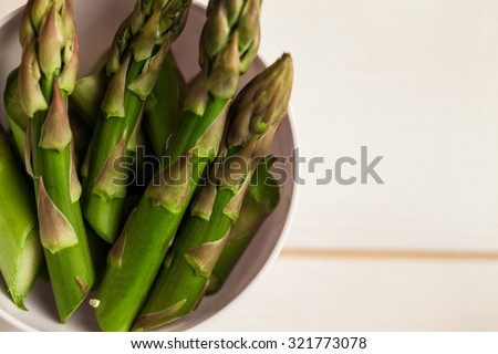 Portion cup of asparagus tips on wooden table