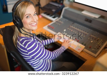 High angle view of happy radio host wearing headphones working in studio