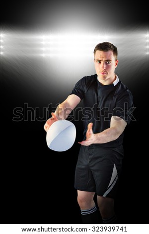 Rugby player about to throw a rugby ball against spotlight