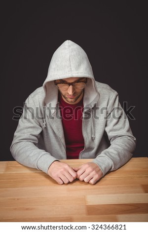 High angle view of man with hooded shirt sitting at desk in office