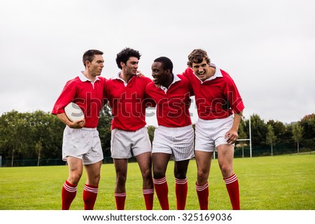 Rugby players smiling with arms around at the park