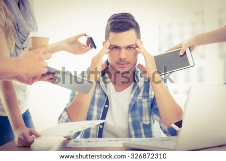 Portrait of depressed businessman with head in hand while sitting at desk