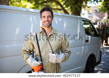 Portrait of smiling worker with pesticide sprayer while standing by van Foto d'archivio © 