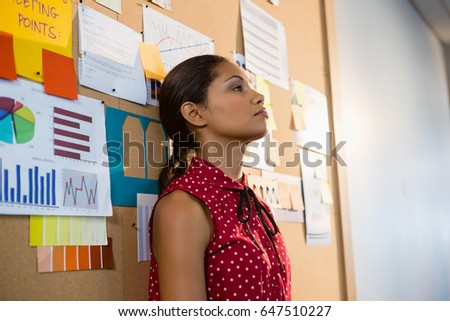 Depressed female executive leaning on bulletin board in office Foto stock © 