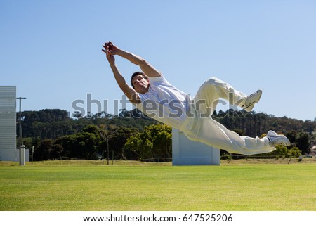 Full length of player diving to catch ball against blue sky over field Stock foto © 