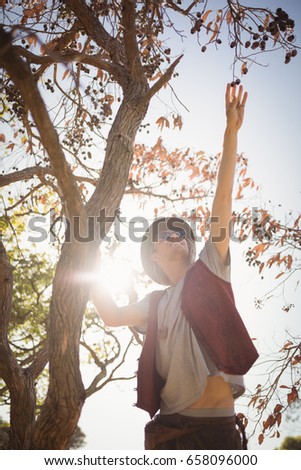 Low angle view of man reaching at fruits hanging on branch against sky during sunny day 商業照片 © 