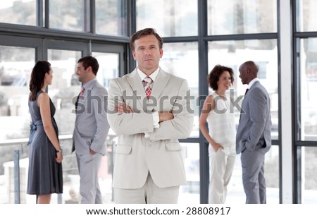 Senior attractive Business man standing in from of Business team