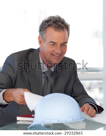 Senior Engineer looking at Blueprints in office