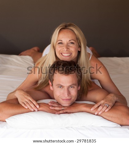 Beautiful woman on a mans back in bed having fun