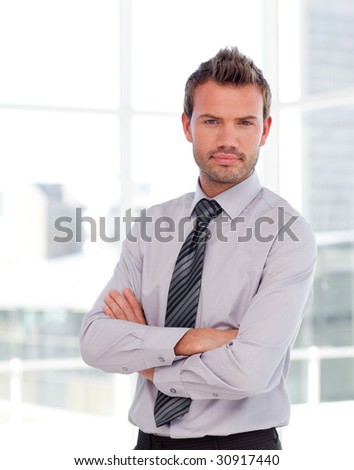 Attractive serious businessman with folded arms