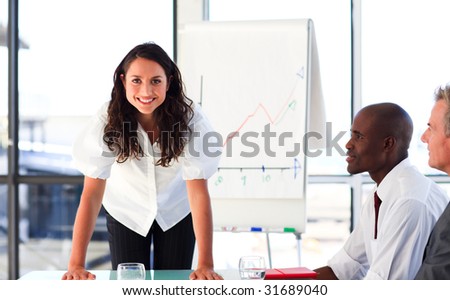 Confident young businesswoman standing in a meeting