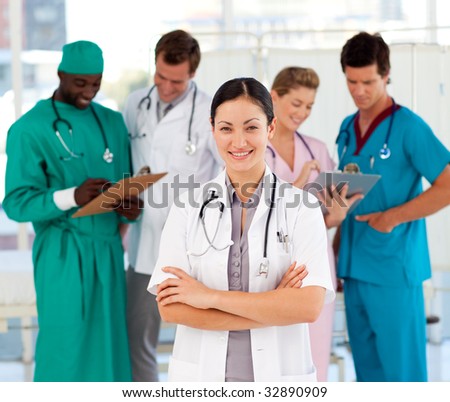 Smiling female doctor with her team in the background