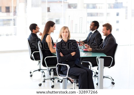 Smiling businesswoman in a meeting with her team in the background