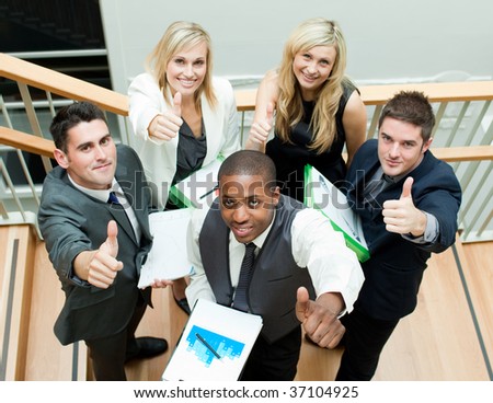 Young business team having a meeting on stairs with thumbs up