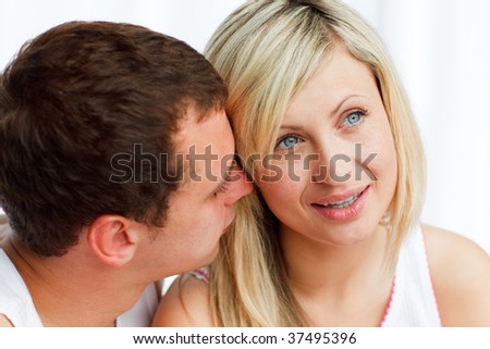 Close-up of a man whispering a woman a secret