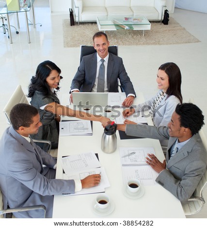 High angle of businesswoman and businessman shaking hands in a meeting