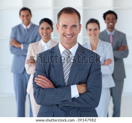 Smiling business manager standing in office leading his team