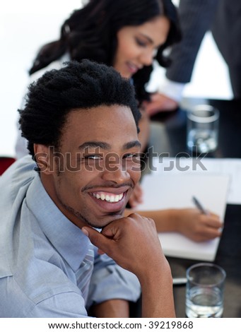 Portrait of a smiling Afro-American businessman in a meeting with his colleagues