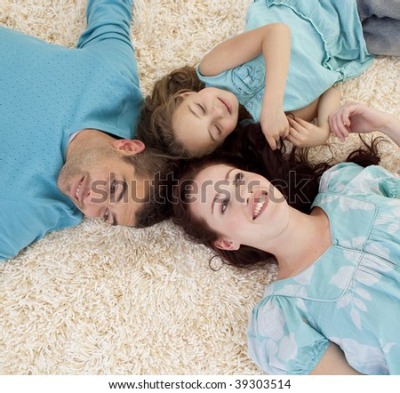 Portrait of parents and daughter lying on floor with heads together