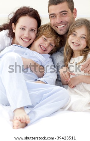 Portrait of young family lying together in bed