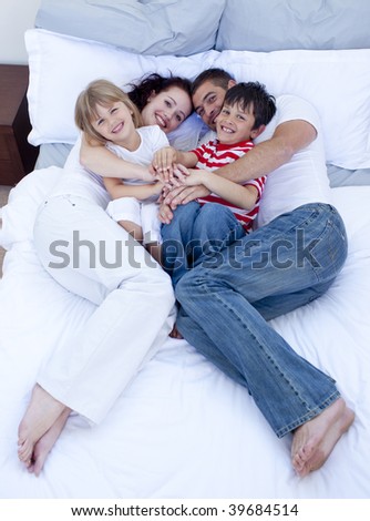 High view of parents and children relaxing in bed together