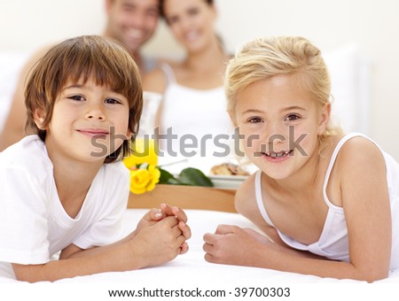 Portrait of children in bed with their parents after having breakfast