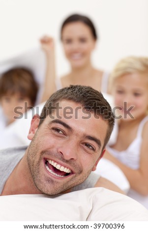 Happy family playing with father in bed