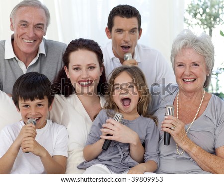 Family singing karaoke with microphones at home