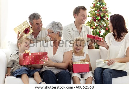 Happy family in sofa giving presents for Christmas