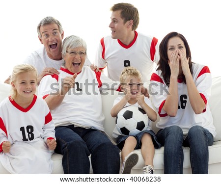 Family watching a football match in television at home