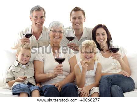 Happy family in living-room drinking wine and eating biscuits
