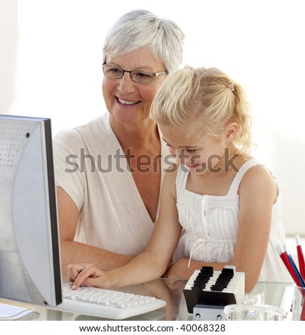 Granddaughter using a computer with her grandmother at home