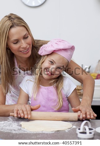 Happy mother and daughter baking in the kitchen together