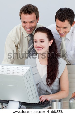 Businessmen helping her colleague with a computer in an office