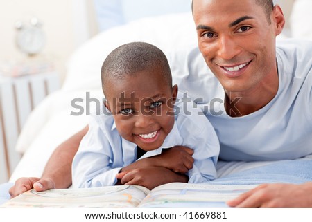 Father and his son reading on bed