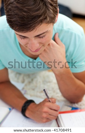 Portrait of a teen guy studying on the floor with his friends
