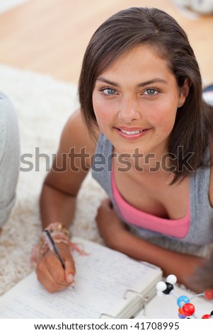 Beautiful teenager studying on the floor with her friends